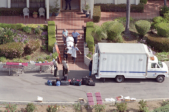 The bodies of Heaven's Gate members are removed from the mansion